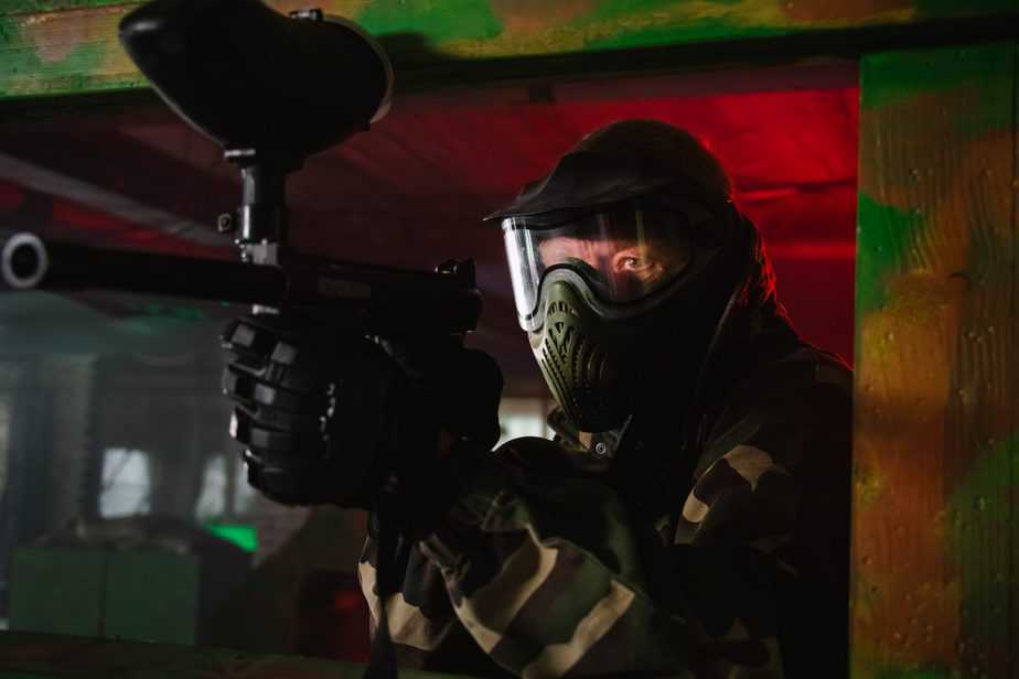 Paintballspelare med mask och markör på inomhusbanan hos Tactical Sports